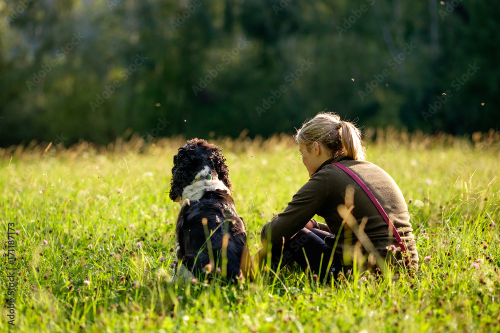 Best friend, woman and dog, sitting on a meadow and enjoying the end of the day with the sunset Best friend, woman and dog, sitting on a meadow and enjoying the end of the day with the sunset