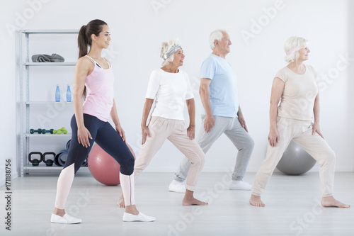 Elderly people exercising with trainer