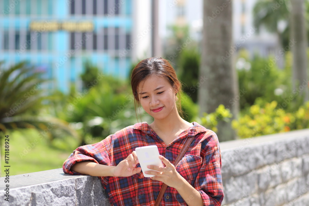 Naklejka premium スマートフォンを使う若い女性