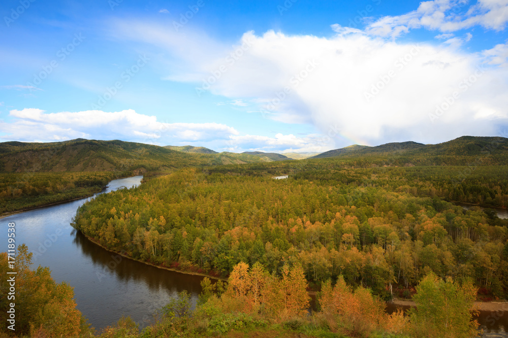 beautiful autumn landscape with river and forest under blue sky