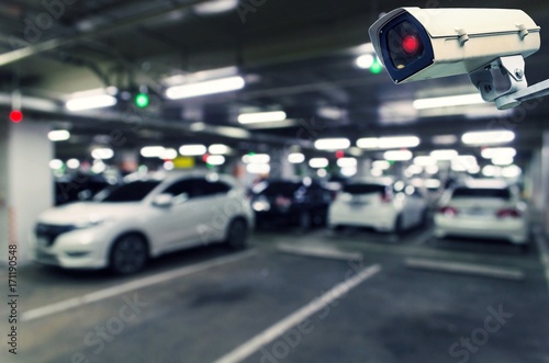 CCTV, security indoor camera system operating with blurred image of under ground indoor car parking garage area, RFID solution management system, surveillance security and safety technology concept © Vittaya_25