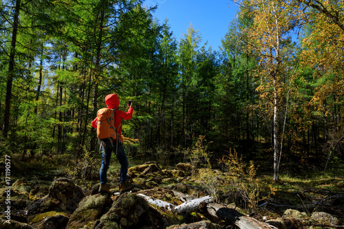 hiking woman use smartphone taking photo in the autumn forest