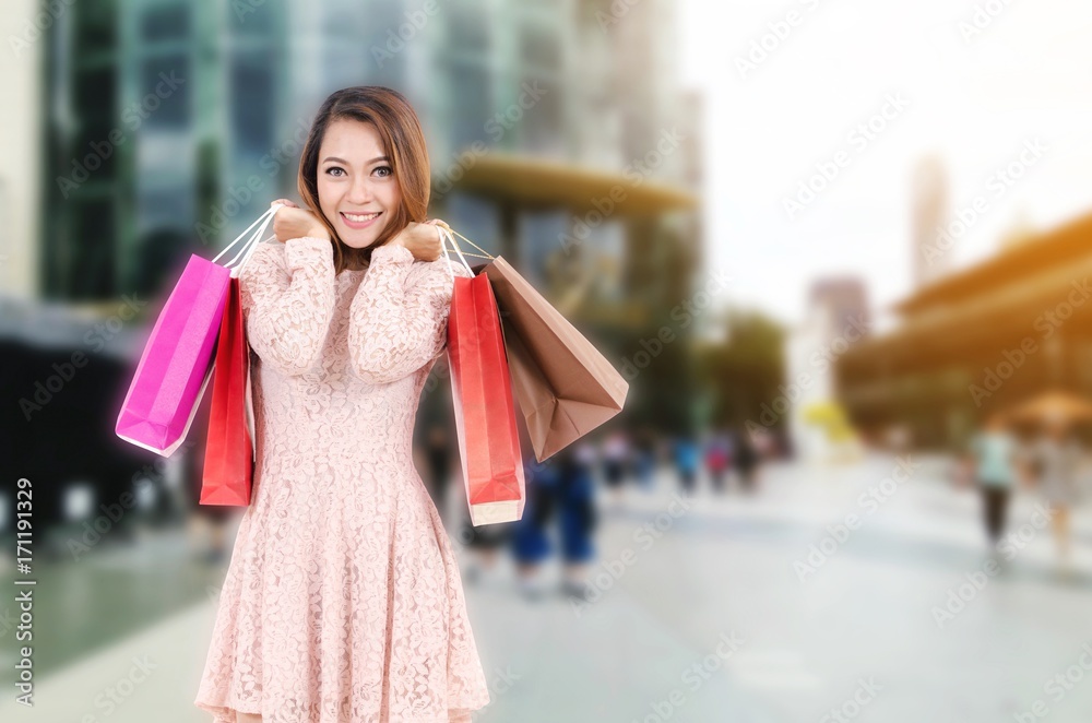 young asian woman beautiful smiling surprise and holding shopping bag while standing at outdoor department store shopping mall, online payment, shopping online, lifestyle concept