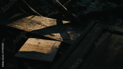 The morning sun shines on old wooden chairs.