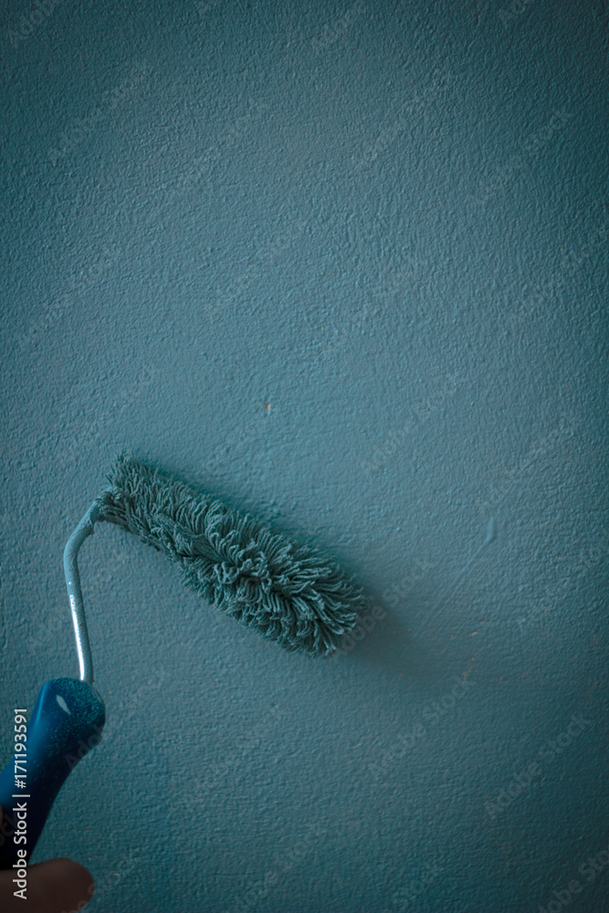 Obraz premium Painting wall by aqua color paints with paint roll.