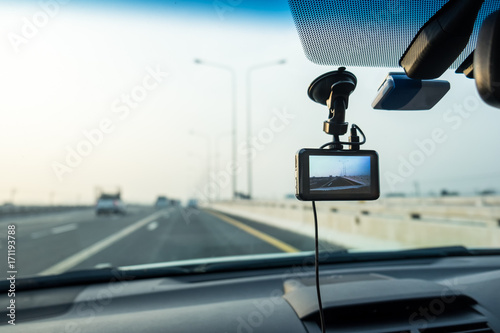 Car video camera (dash cam) inside of car on highway with blurred background of highway road, from perspective of the driver. Concept of safety camera for car protection, technology for safety