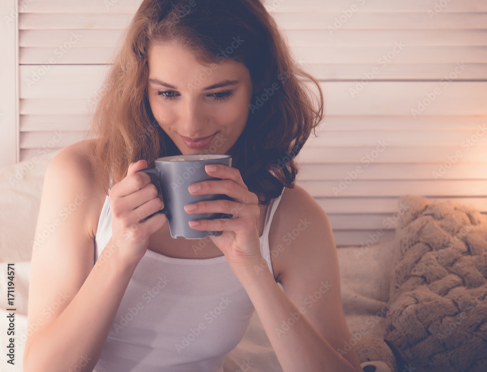 Pretty woman drinking coffee sitting on bed at home Pretty woman drinking coffee sitting on bed at home