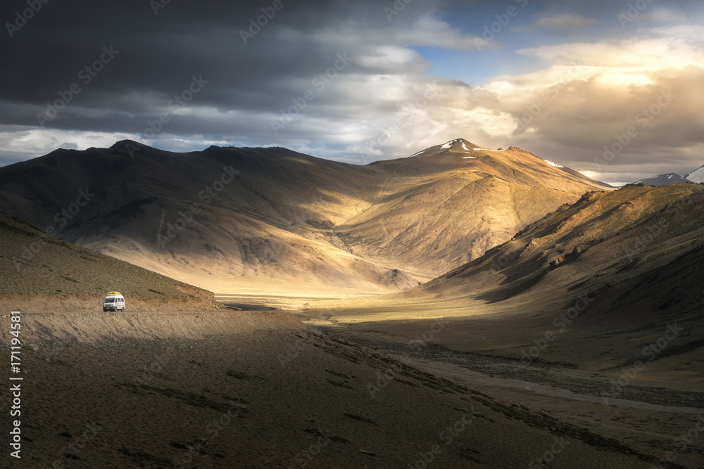 View of Leh Manali highway road on Himalayan range mountain with dramatic light shade on the road. Ladakh, Jammu and Kashmir, India.