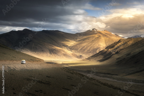 View of Leh Manali highway road on Himalayan range mountain with dramatic light shade on the road. Ladakh, Jammu and Kashmir, India.