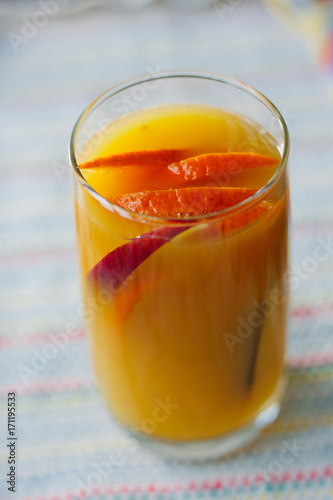 Mango and orange smoothie in transparent glass.