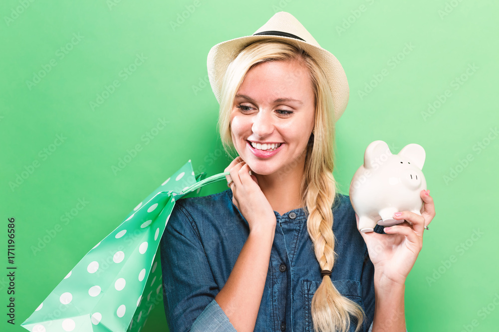 Happy woman holding a piggy bank and shopping bags Happy woman holding a piggy bank and shopping bags