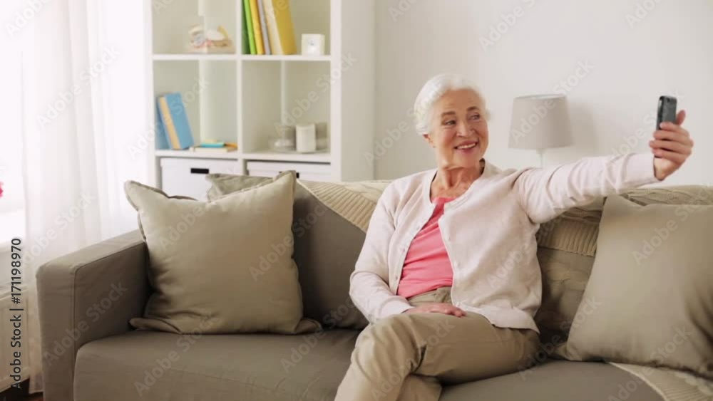 senior woman with smartphone taking selfie at home senior woman with smartphone taking selfie at home