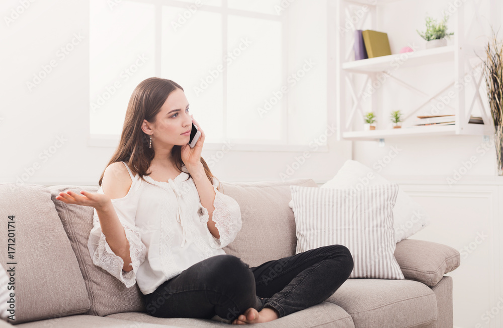 Young worried woman talking on cellphone Young worried woman talking on cellphone
