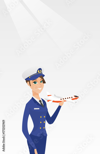 Young caucasian airline pilot holding the model of airplane in hand. Cheerful female airline pilot in uniform. Smiling pilot with the model of airplane. Vector cartoon illustration. Vertical layout.