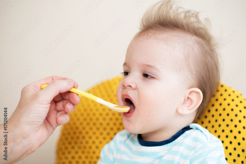 grandmother gives baby food from a spoon grandmother gives baby food from a spoon
