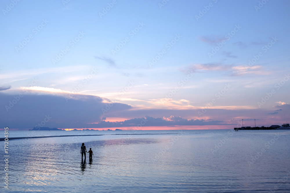 children and parent holding hand looking to the sea at sunset, family, peaceful concept.