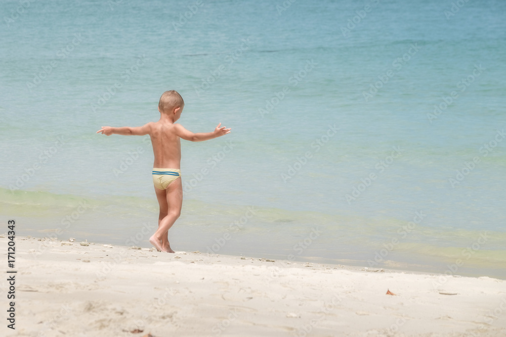 European boy age 3-5 years old stands on the beach, Opening arm.5 years old stands on the beach, Opening arm. European boy age 3-5 years old stands on the beach, Opening arm.5 years old stands on the beach, Opening arm.