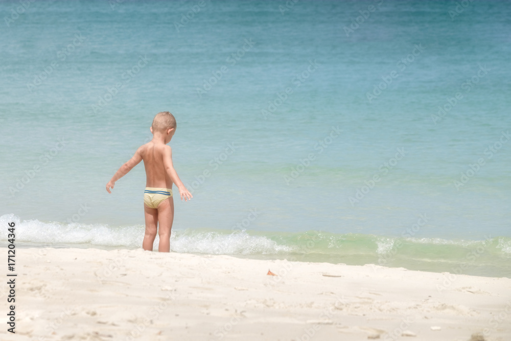 European boy age 3-5 years old stands on the beach, Opening arm.
