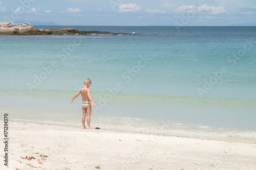 European boy age 3-5 years old stands on the beach, Opening arm.