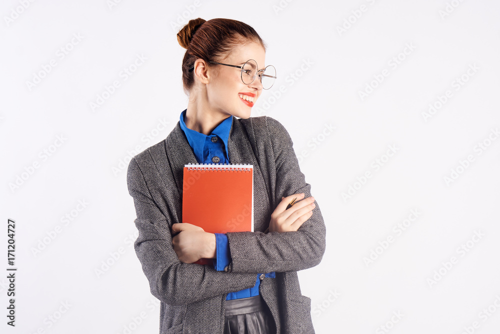 teacher woman with glasses holds a notebook and smiles teacher woman with glasses holds a notebook and smiles