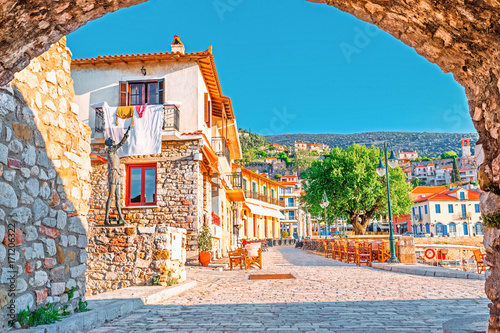 View on old medieval Greek city Nafpfktos Though arch in ancient medieval castle wall, popular and famous travel landmark. Nafpaktos is popular European travel destination. Old houses on embankment.  photo