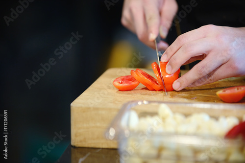 chef hands are cutting tomatoes