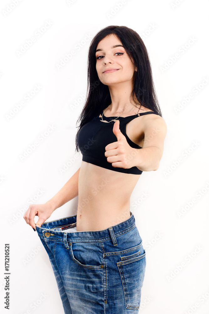 Fit girl with slim body shape in big jeans pants. Stock Photo