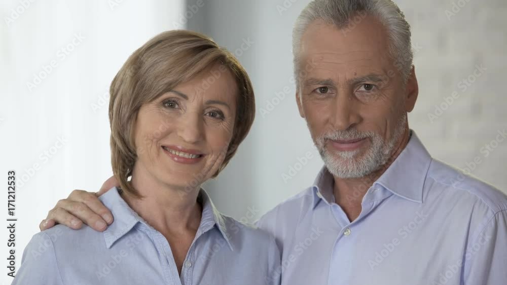 Happy elderly couple looking at each other and smiling at camera, advertising Happy elderly couple looking at each other and smiling at camera, advertising