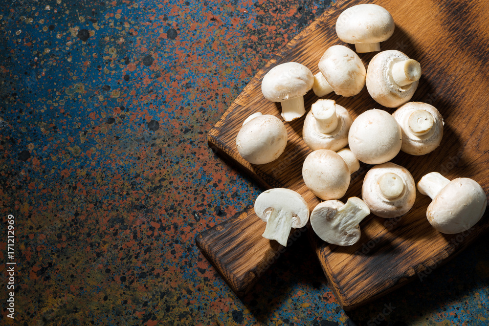 fresh organic mushrooms on vintage cutting board, top view