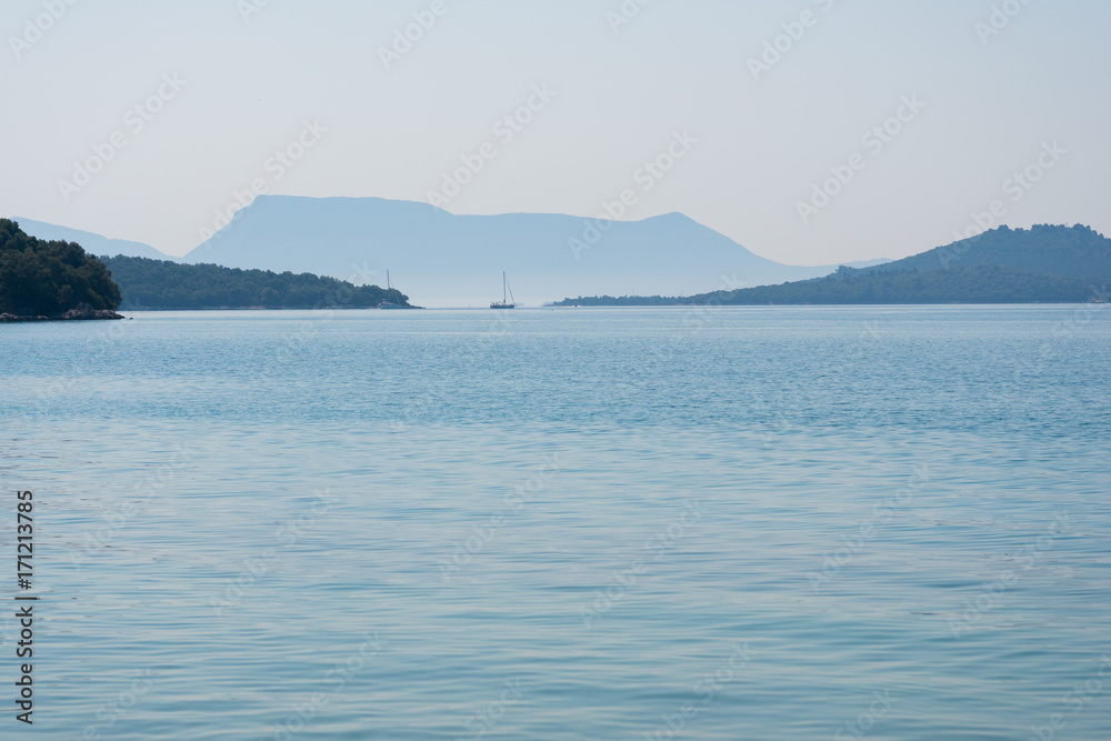 Sailboat on the sea with mountains in the distance