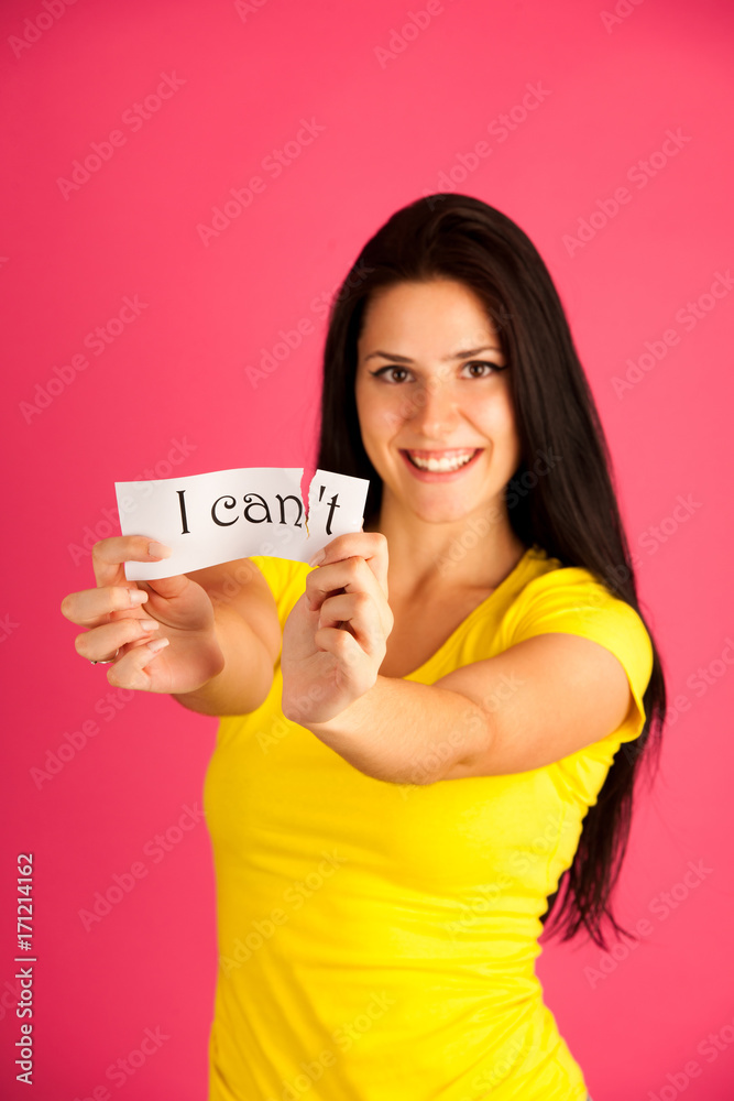 active young woman tearing apart text I can't active young woman tearing apart text I can't