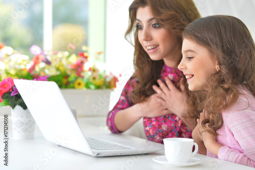 woman and little girl using   laptop