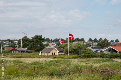 Summer homes and Danish flag in front of vacation homes in Karrebaeksminde in Denmark photo
