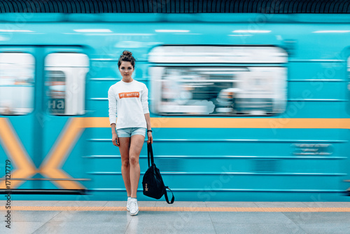 Beautiful young girl posing on metro station