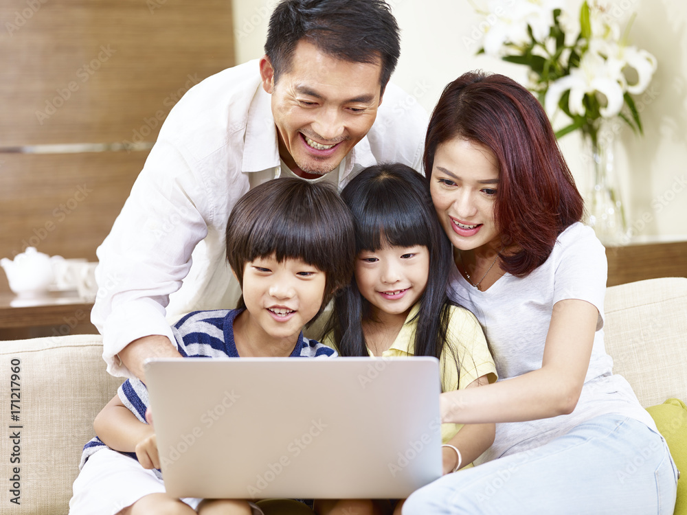 asian family with two children using laptop together asian family with two children using laptop together