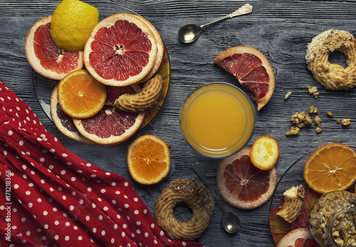 Orange, grapefruit and lemon on the table with nuts and honey