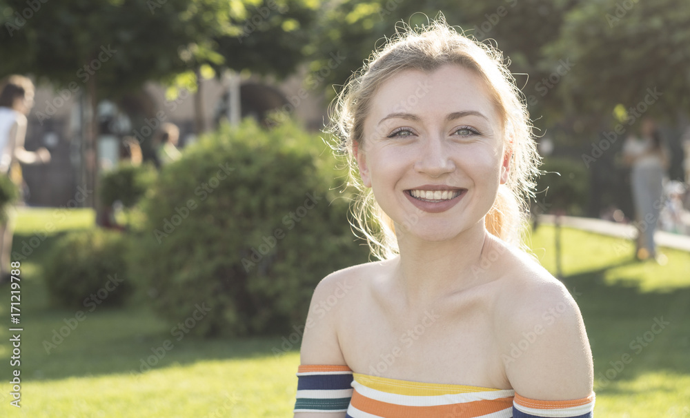 portrait of a beautiful smile young blonde girl in a city park, central park on a sunny day portrait of a beautiful smile young blonde girl in a city park, central park on a sunny day
