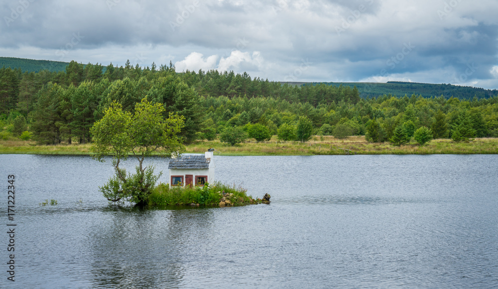 Obraz premium The Wee Hoose, a small house built in Loch Shin, near Lairg in the Scottish North West Highlands.