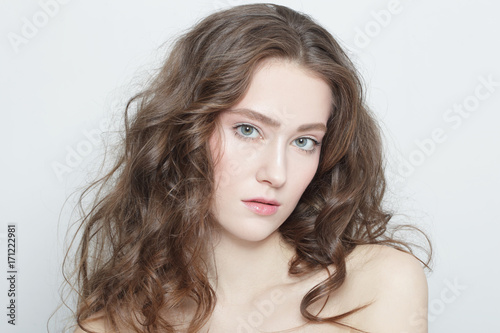 Young beautiful girl with clear skin and long healthy curly hair