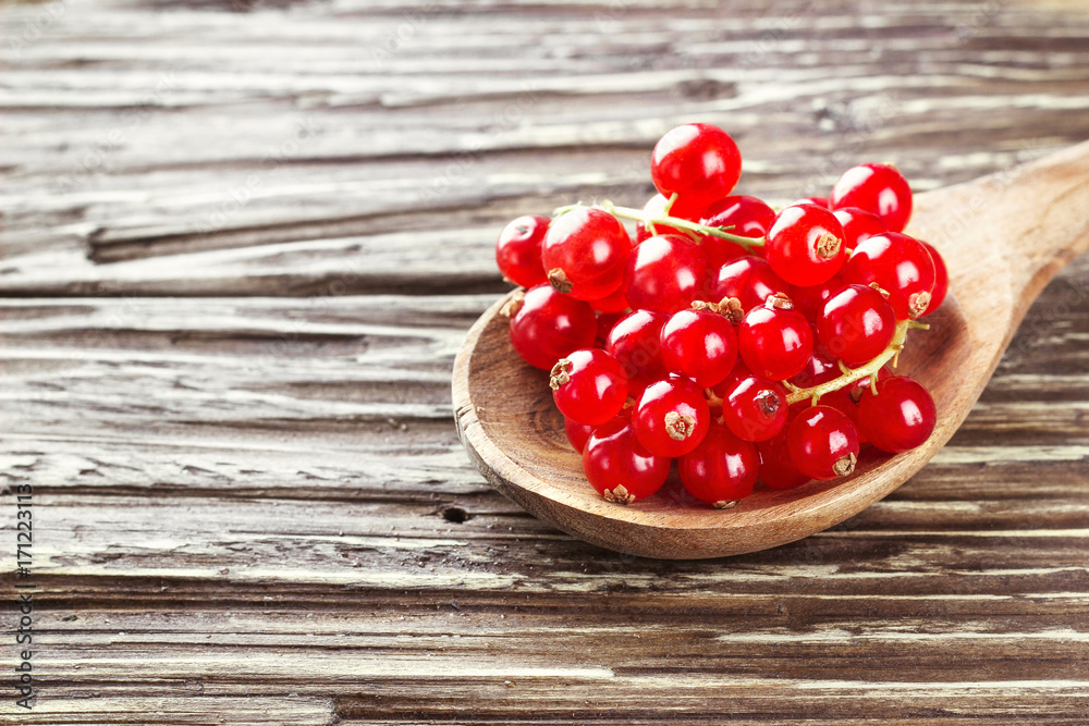Fresh harvested redcurrant in wooden spoon on rustic wooden table background, selective focus, copy space. Fresh harvested redcurrant in wooden spoon on rustic wooden table background, selective focus, copy space.