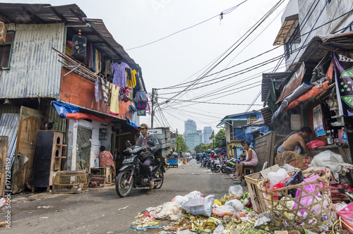 Pure dirty street with trash and skyscrapers on the background in Jakarta, Indonesia