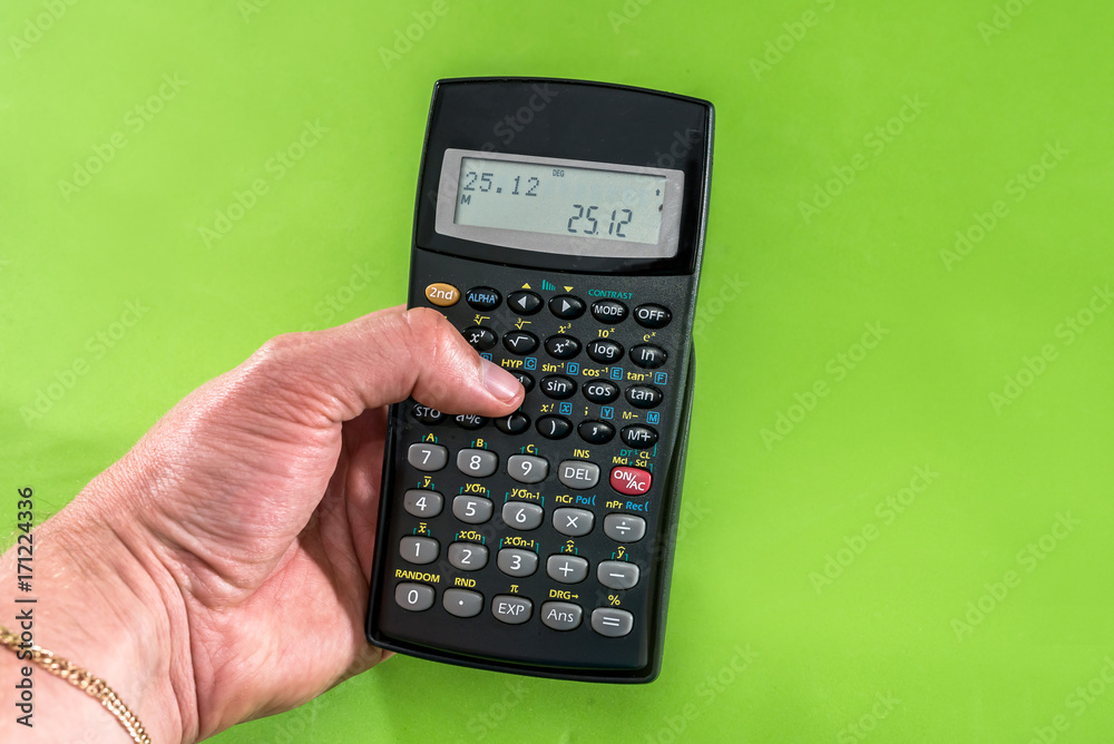 hand holding digital calculator isolated on green hand holding digital calculator isolated on green