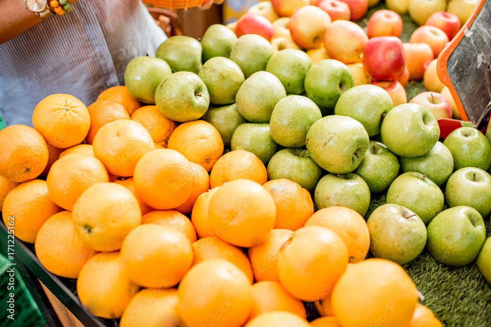 A heap of apples and oranges on the showcase of food market