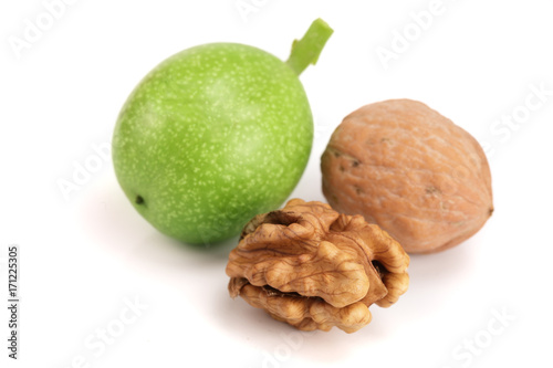 fresh walnuts in peel isolated on white background