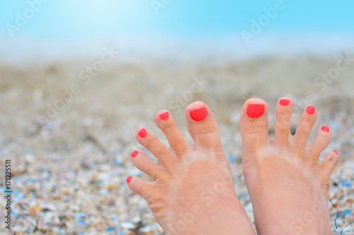 Woman toes with pedicure in a funny trip on a beach