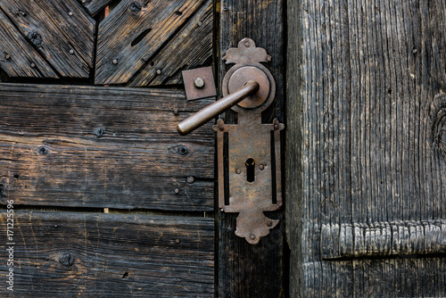 Old Door Handle. Foreground of old wooden door with iron handle.. © krstrbrt