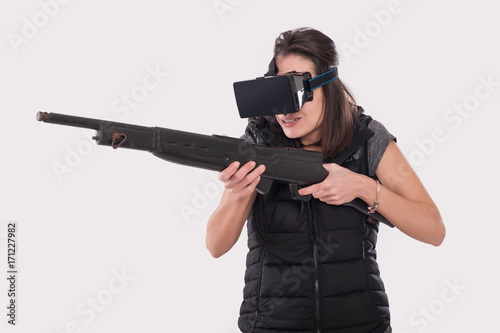 Woman play VR shooter game with vr glasses and rifle