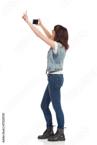 Side View Of Woman Taking Photo With A Cell Phone