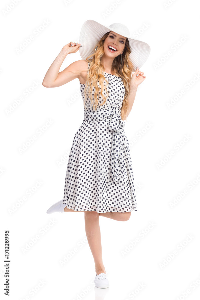 Excited Beautiful Young Woman In Sun Hat Is Standing On One Leg And Laughing Excited Beautiful Young Woman In Sun Hat Is Standing On One Leg And Laughing