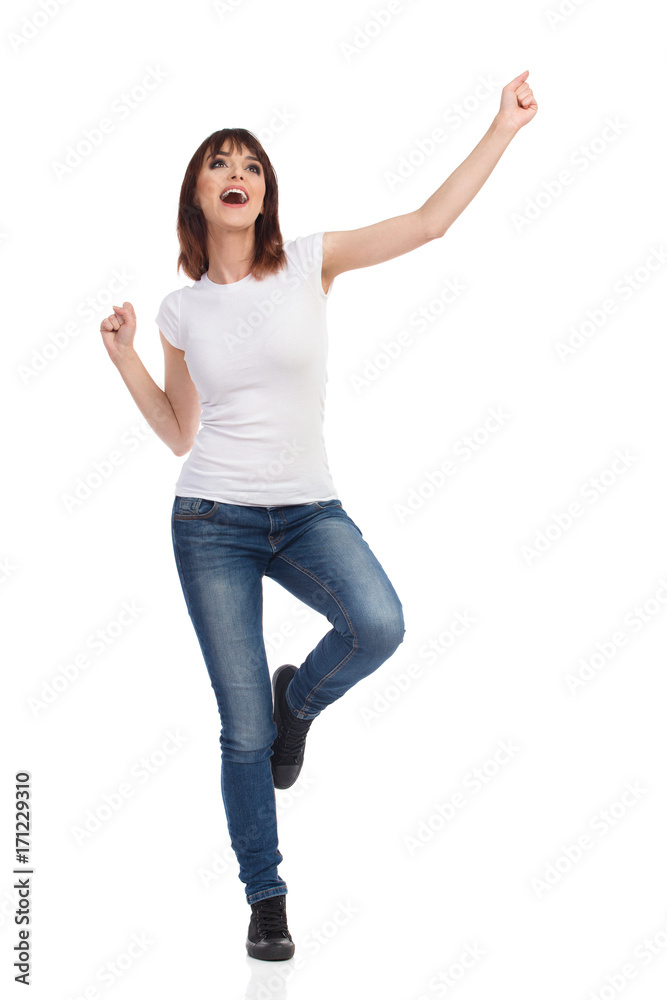 Happy Young Woman Is Standing On One Leg, Gesturing And Shouting Happy Young Woman Is Standing On One Leg, Gesturing And Shouting